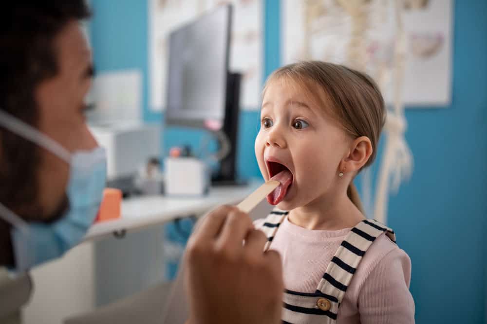 Find Relief. Feel Like Yourself Again - Doctor examining a child's throat for throat and tonsil disorders